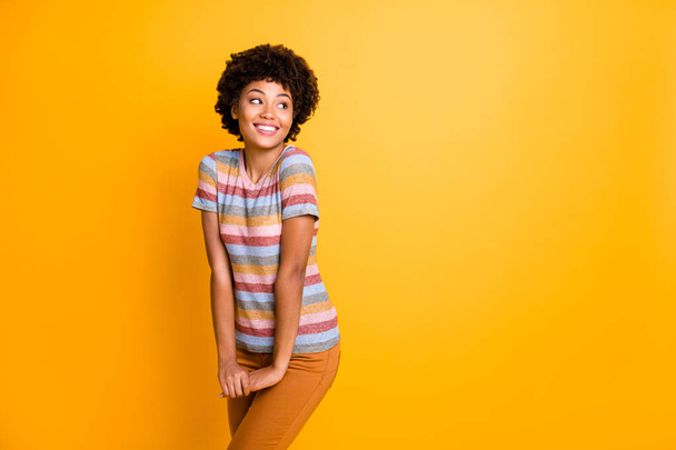 Photo of pretty dark skin lady shy person coquettish mood flirting with handsome guy wear casual striped t-shirt trousers isolated yellow background - Foto, Imagen