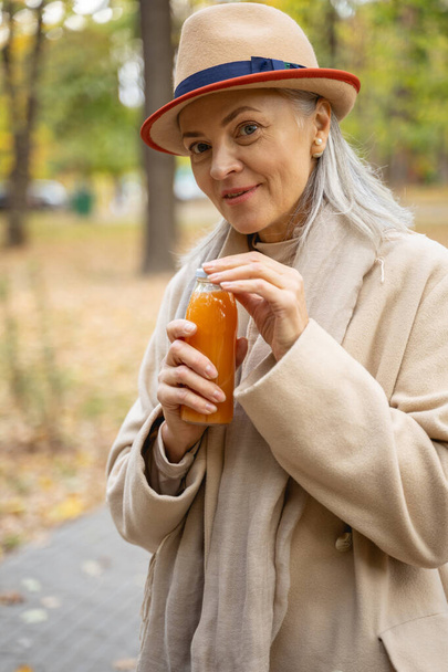 Female with a bottle of orange juice - Фото, зображення