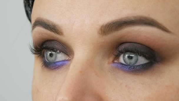 Όμορφο ακριβό κομψό βράδυ make-up smoky μάτια ασυνήθιστη γκρι και μπλε απόχρωση της σκιάς ματιών. Όμορφη γυναίκα μπλε μάτια από κοντά θέα - Πλάνα, βίντεο