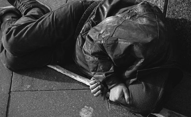 Бездомний і голодний чоловік спить на вулиці
  - Фото, зображення