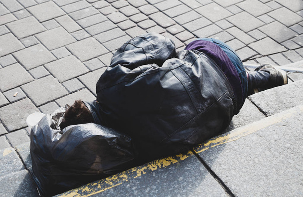 бездомний чоловік спить на вулиці
 - Фото, зображення