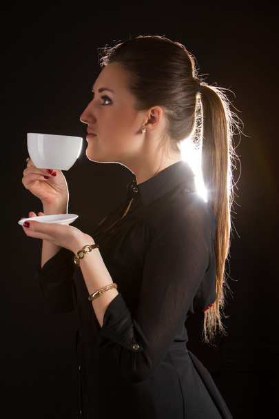 Portrait of beautiful woman posing in studio with cup of coffe - Photo, Image