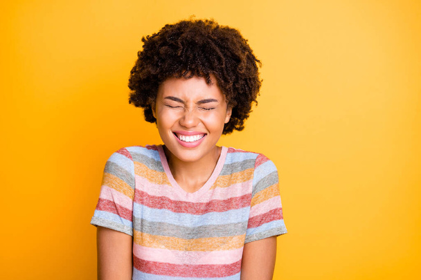 Photo of cheerful cute nice pretty sweet beautiful girl smiling toothily wearing striped t-shirt with eyes shut because of laughing enjoying joke isolated over vivid color background - Fotó, kép