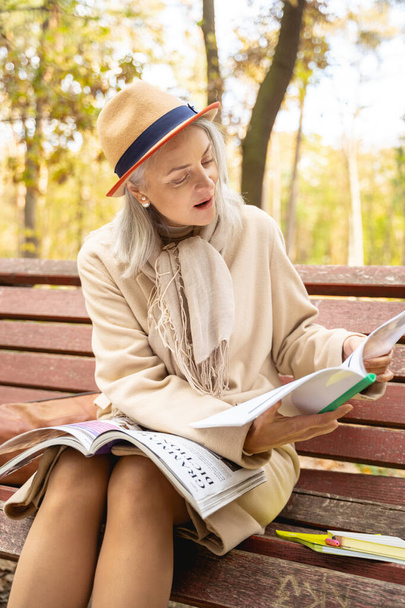 Motivated mature female student reading a textbook - 写真・画像