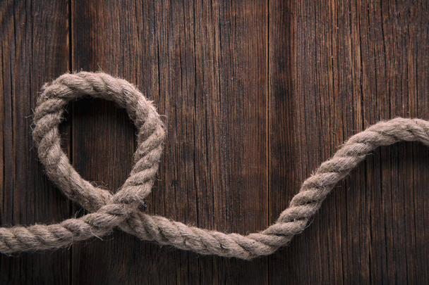 Thick twisted rope on a wooden background - Photo, Image