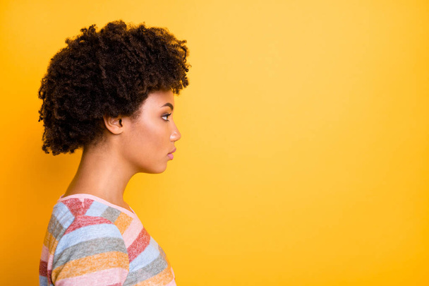 Profile photo of amazing dark skin lady looking seriously empty space not smiling wear casual striped t-shirt isolated bright yellow background - Valokuva, kuva