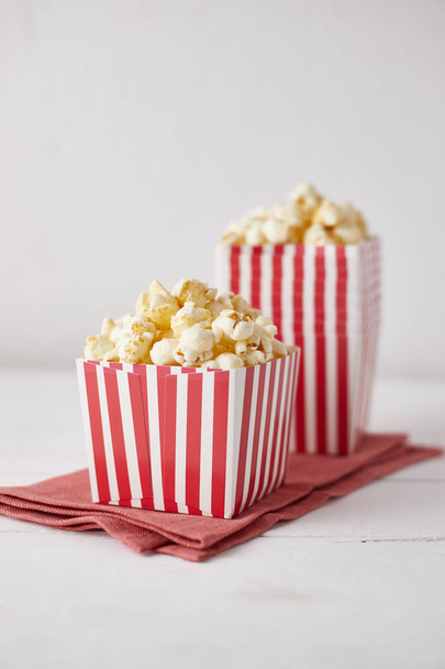 Full of tasty caramel popcorn in classic striped box - Foto, immagini