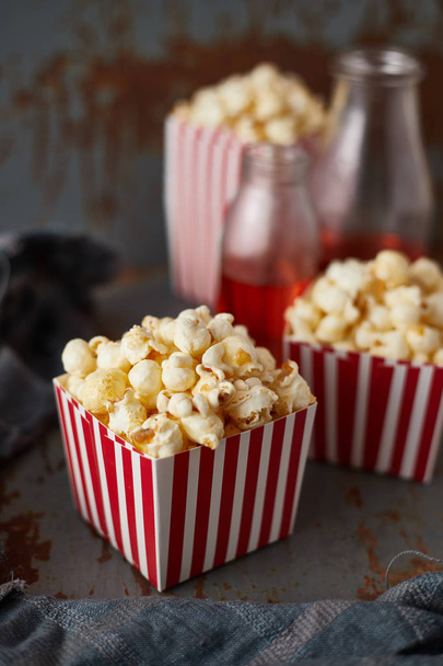 Full of tasty caramel popcorn in classic striped box - Foto, afbeelding
