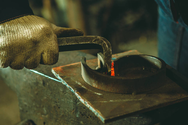 Elemento incandescente no ferreiro na bigorna de ferro
 - Foto, Imagem