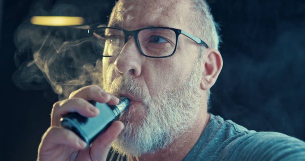 Mann, der einen umstrittenen Dampf raucht, ist ein Gesundheitsrisiko - Foto, Bild