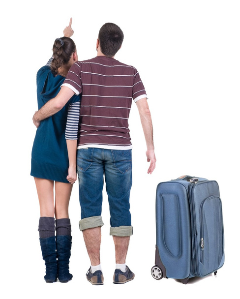 Young traveling couple with suitcas looks where that. - Фото, изображение