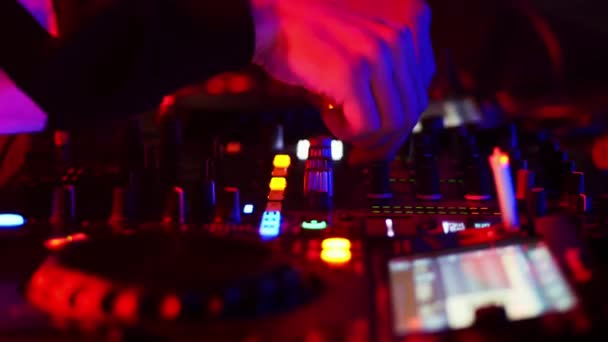 Egy közeli felvétel DJ-ről, amint a távirányítóval dolgozik az éjszakai klubban.. - Felvétel, videó