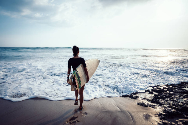 フィット女性サーファーとサーフボードへサーフで海辺に行く - 写真・画像