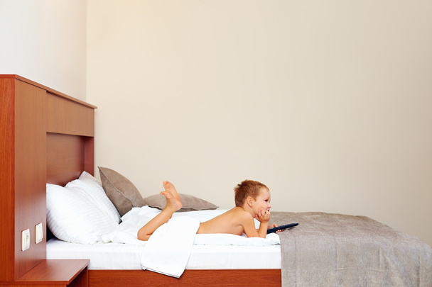 happy kid watching tv in hotel room after bathing - Foto, imagen