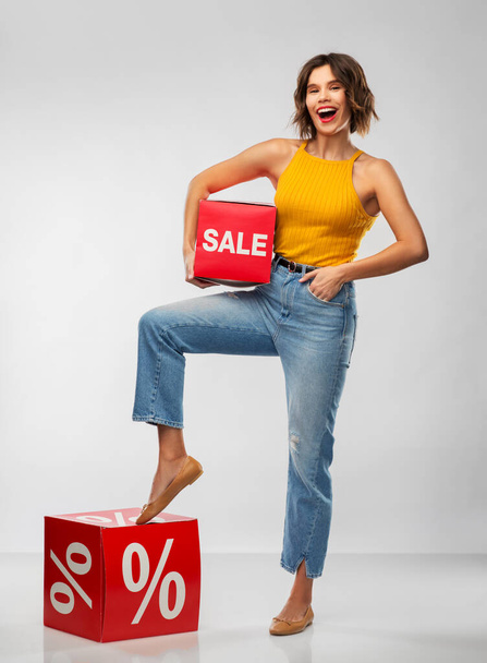 happy smiling young woman with sale signs - Foto, Bild