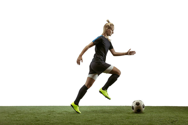 Θηλυκός ποδοσφαιριστής που κλωτσάει μπάλα στο στάδιο - Φωτογραφία, εικόνα