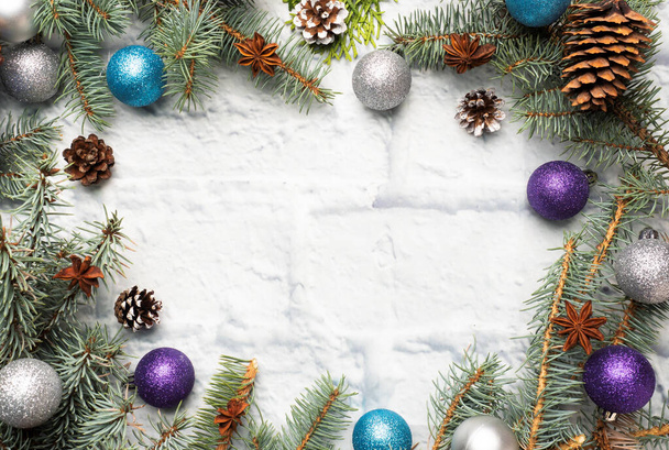 Marco de Navidad hecho de abeto, decoraciones de árboles de Navidad en plata y azul sobre un fondo de ladrillo claro. Copiar espacio. Puesta plana
. - Foto, imagen