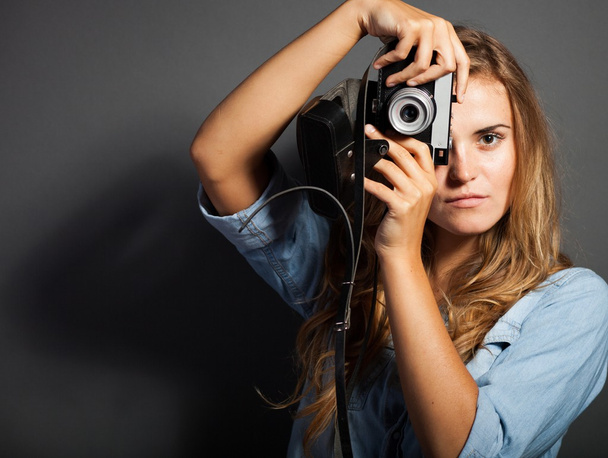 Young photographer in jeans jacket with old camera - Photo, Image