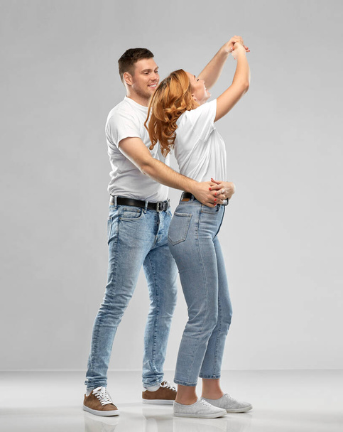 portrait of happy couple in white t-shirts dancing - 写真・画像