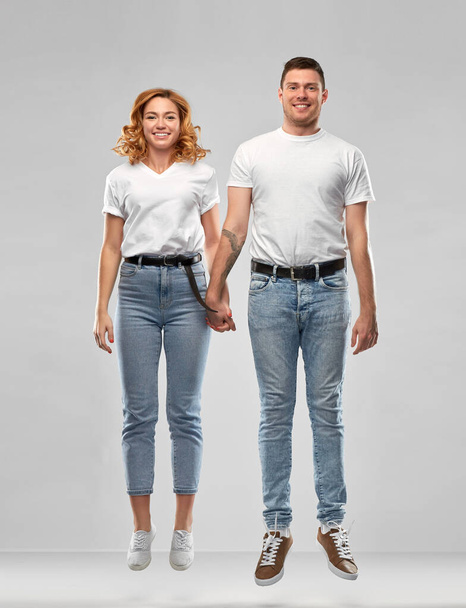 happy couple in white t-shirts jumping or hanging - Φωτογραφία, εικόνα
