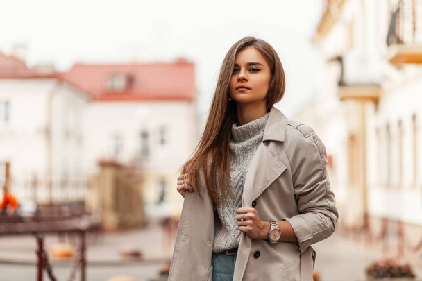 Elegant young pretty woman in stylish autumn-spring clothes stands on a street in the city near vintage buildings in the street. Attractive girl in trendy outerwear outdoors. Fashion women's clothing. - Photo, Image