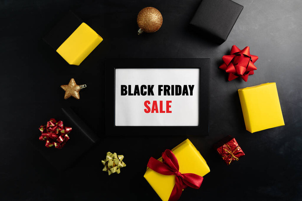Geschenkbox mit Fotorahmen für Black Friday Sale Konzept auf schwarzem Hintergrund - Foto, Bild