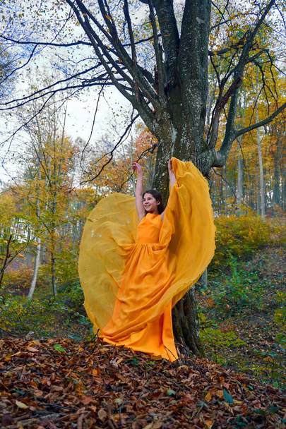 Teenage girl in yellow dress in the forest - Zdjęcie, obraz