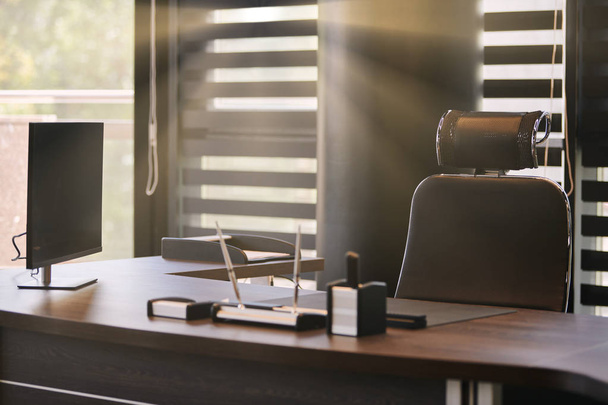 İş yeri işyeri. Şef, patron veya diğer çalışanlar için iş yerinde Güneş ışığı. Masa ve rahat sandalye. Yarı açık güneşliklerden ışık - Fotoğraf, Görsel
