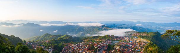 Widok z lotu ptaka na Phongsali w północnym Laosie niedaleko Chin. Miasto w stylu Yunnan na malowniczym grzbiecie górskim. Cel podróży dla plemiennych wędrówek w wioskach Akha. Mgła i mgła w dolinie. - Zdjęcie, obraz