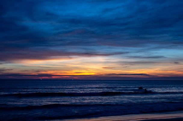 Niebieski zacieniony zachód słońca na plaży Karon nad oceanem - Zdjęcie, obraz