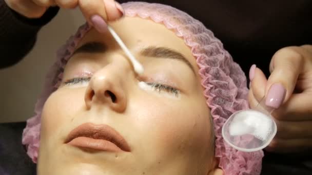 ein professionelles Verfahren zum Laminieren und Botox-Wimpern moderne Heilung im Schönheitssalon. ein spezieller Reinigungs- und Desinfektionsschaum wird von einem Kosmetologen auf die Wimpern aufgetragen - Filmmaterial, Video