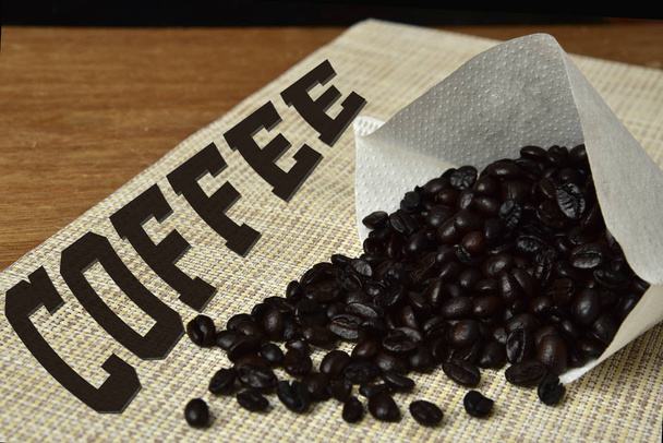 granos de café tostados en la mesa con la palabra café
 - Foto, imagen