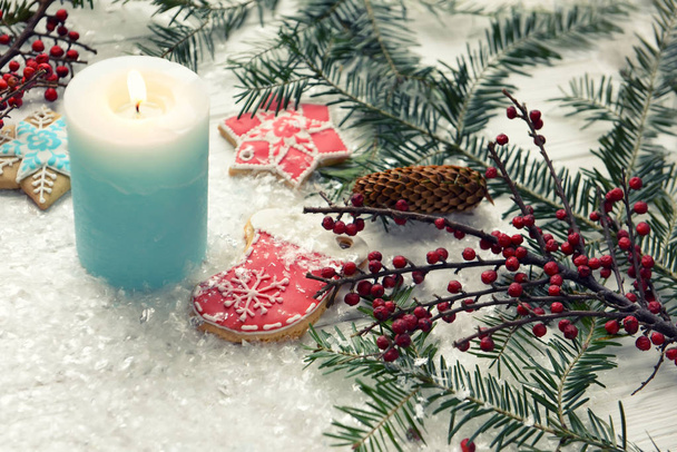 Christmas decorations for Christmas, wreaths and a candle and homemade gingerbread on a light background. The atmosphere of the holiday, Christmas mood. - Фото, изображение
