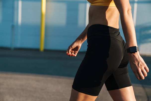 Cropped image closeup of runner woman in sportswear walking outd - Фото, изображение