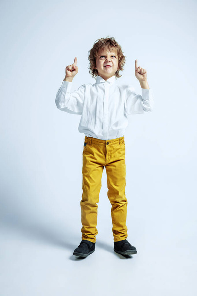 Pretty young boy in casual clothes on white studio background - Фото, зображення
