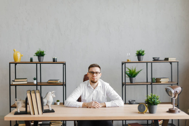 Best work. Attractive exuberant man sitting at the table - Фото, изображение