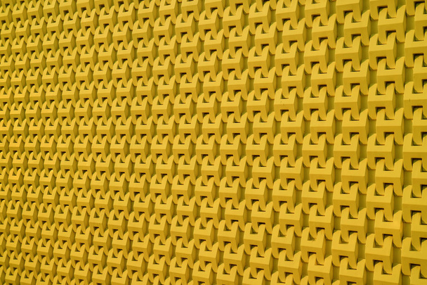 Διακοσμητικό σχέδιο του σύγχρονου εξωτερικού τοίχου του κτιρίου σε κίτρινο χρώμα μουστάρδας - Φωτογραφία, εικόνα