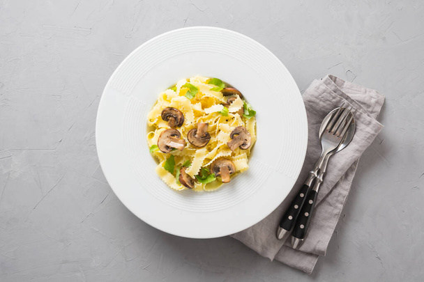 Spaghetti reginelle pasta with mushrooms on grey stone table. Tasty healthy dinner. - Foto, imagen