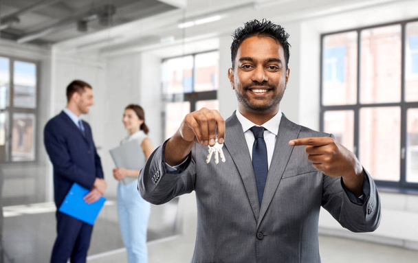 indian man realtor with keys at empty office room - Foto, immagini