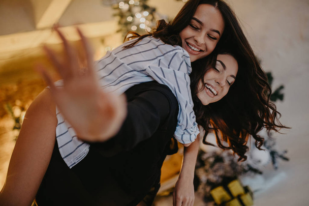 Lesbian couple has a fun against background of Christmas decorat - Photo, Image