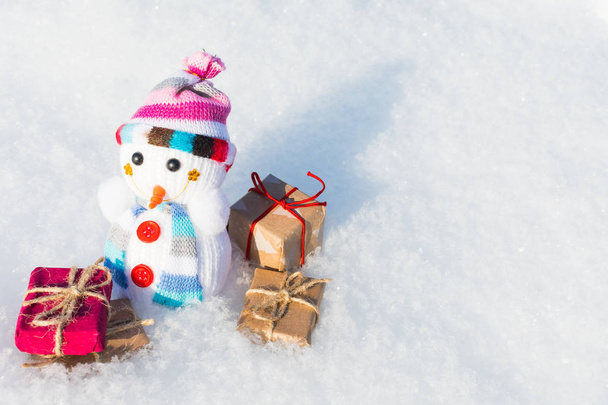 bonhomme de neige jouet avec des cadeaux dans la neige
 - Photo, image