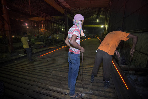 Bangladesh – May 20, 2015: Heated metal gets squeezed and running, risky workers in steel f - Φωτογραφία, εικόνα