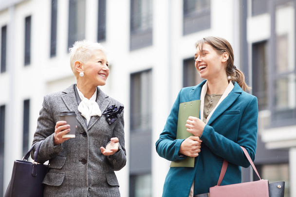Zwei erfolgreiche Geschäftsfrauen unterhalten sich auf der Straße in der Stadt - Foto, Bild