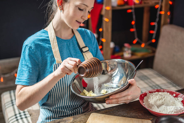 Giovane donna casalinga fa pasta per cucinare biscotti allo zenzero vacanza. Atmosfera domestica la sera della vigilia di Natale
 - Foto, immagini