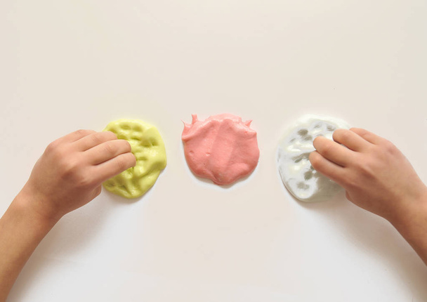 Child hands with slime on background. - 写真・画像