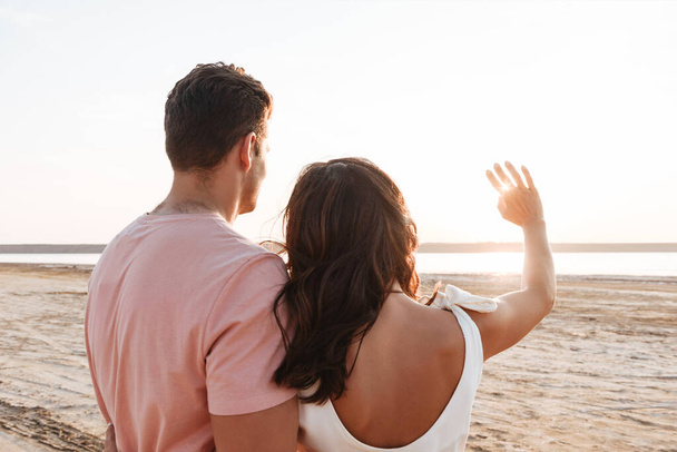 Beautiful young couple wearing summer clothing standing at the beach - Valokuva, kuva