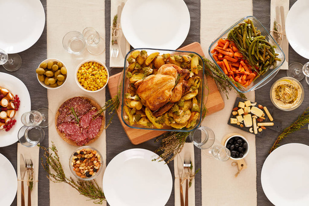 Vista de alto ângulo de peru assado, legumes e outros pratos na mesa servida
. - Foto, Imagem