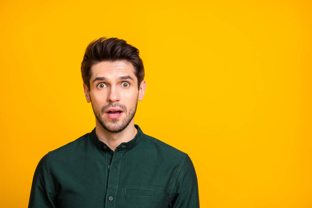 Photo of fearful man seeing terrible things occurring with negative stressful emotions on face in green shirt isolated vivid color background - Fotó, kép