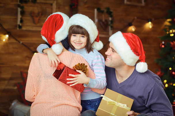Anya és apa egy gyerekkel ajándékot adnak karácsonykor. - Fotó, kép