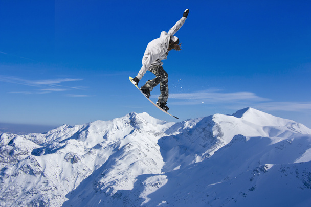 Skier Snowboarder jumping through air with sky in background - Photo, Image